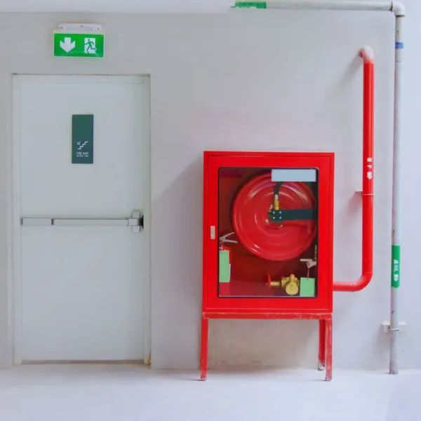 Red Fire hose box placed alongside the emergency exit door.