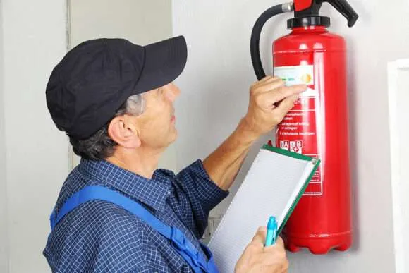 A technician inspecting a fire extinguisher